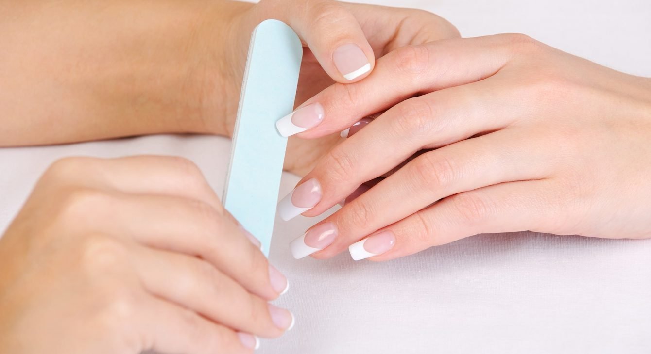 manicurist-doing-polishing-female-fingernails-with-french-manicure